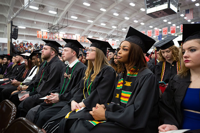 A group of students sitting at their commencement ceremony