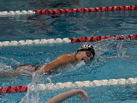 Male student swimming in race